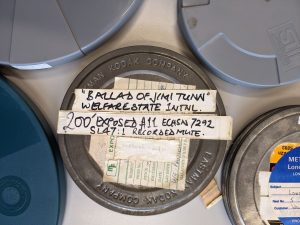 Metal film canister from WSI archive labelled with white tape that reads 'Ballad of Jimi Tunn' Welfare State Intl