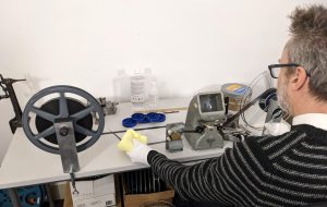 Man manually winding 16mm film from reel onto core