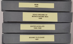 Pictures of archival boxes with the names of DV8 productions written on them.